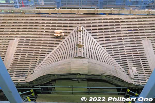 Corridor's roof framing is exposed as it awaits new wood shingles