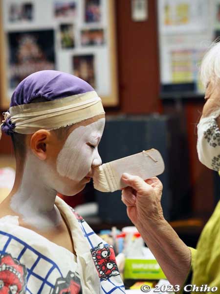 Putting on kabuki makeup on the boys.