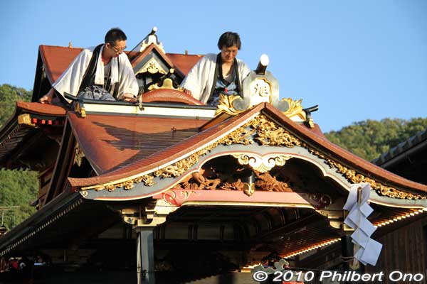 Two men on the Asahiyama float’s ornate roof